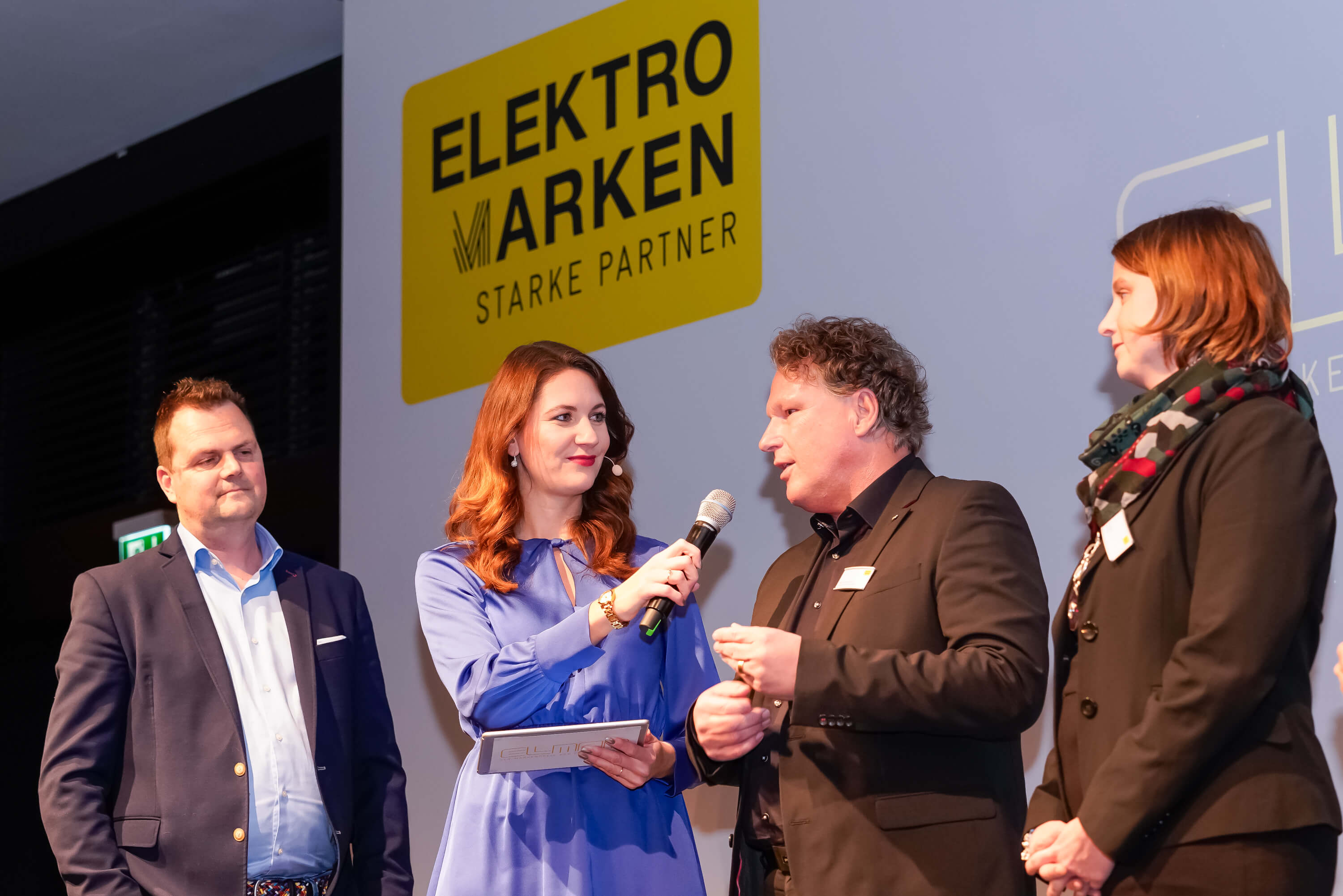 Interview Jury bei der ELMAR 2023: Moderatorin spricht mit der Jury von Elektromarken Starke Partner auf der Bühne.