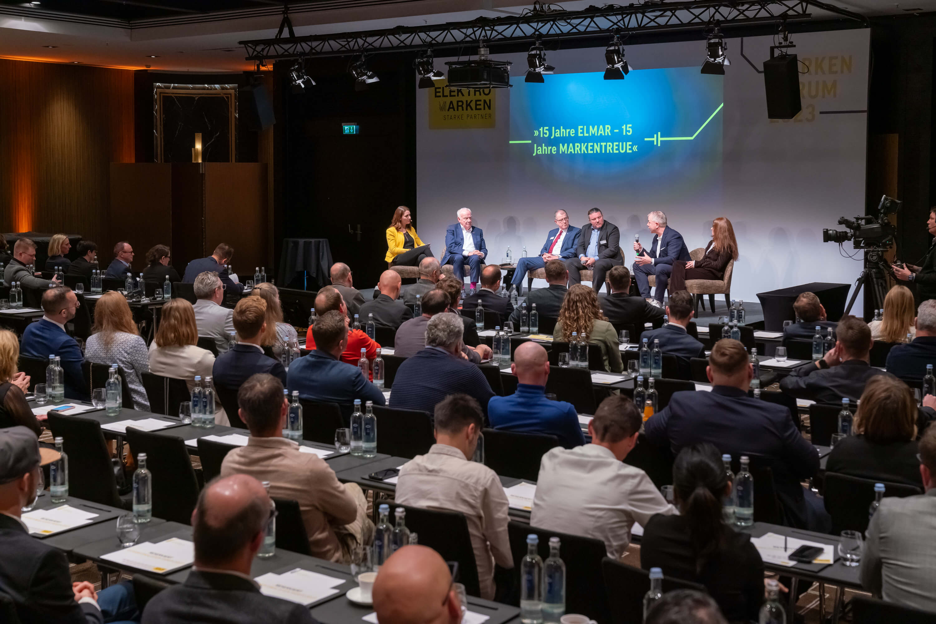 Podiumsdiskussion bei der ELMAR 2023: Experten diskutieren vor Publikum über 15 Jahre ELMAR und die Bedeutung von Markentreue.