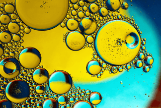 Innovation - gelb-blaues Bild von einer klaren Flüssigkeit in der zahlreiche Blasen enthalten sind; Bild fotografiert von David Clode
