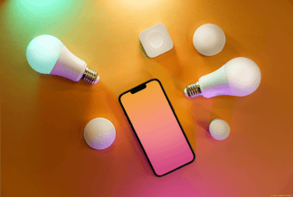 Smartphone und IoT-fähige Geräte auf orangem Hintergrund; Bild fotografiert von Jakub Zerdzicki