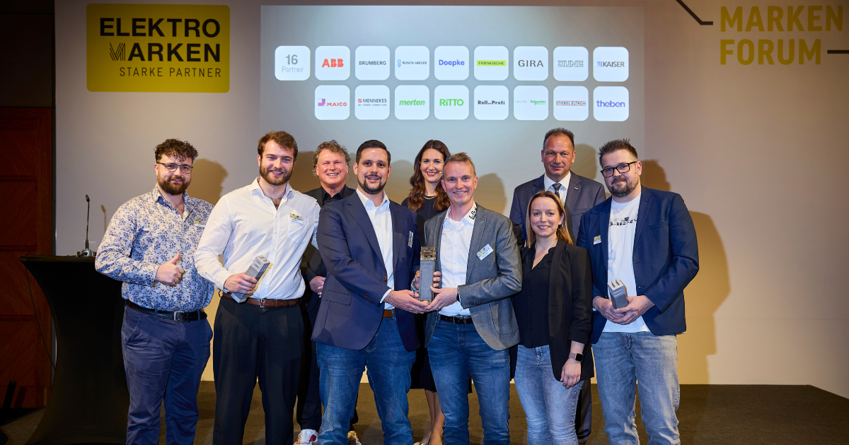 Gruppenfoto einer weiteren ELMAR-Gewinnergruppe 2025 beim Markenforum, alle mit Trophäen auf der Bühne.