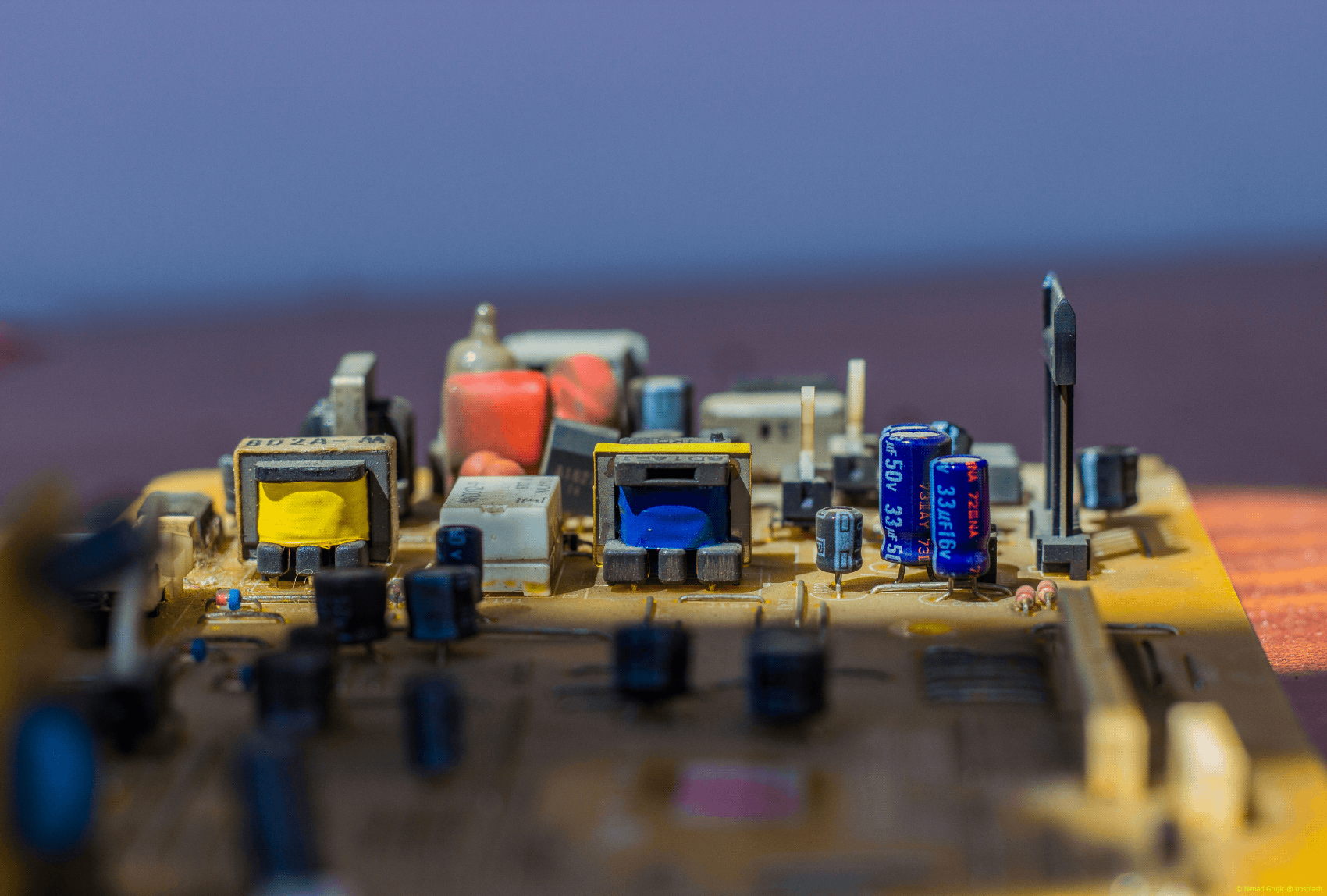 Leiterplatine mit bunten Elektronik-Bauteilen als Nahaufnahme