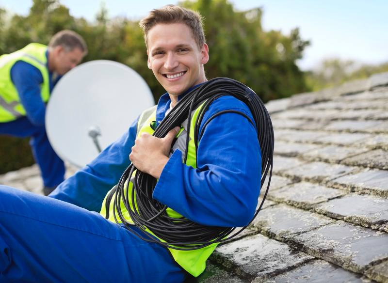 Elektriker installiert Satellitenschüssel auf einem Dach