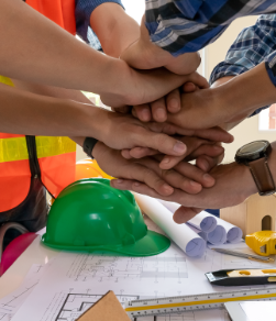 Hände von Handwerkern übereinander gelegt, als Symbol der Zusammenarbeit