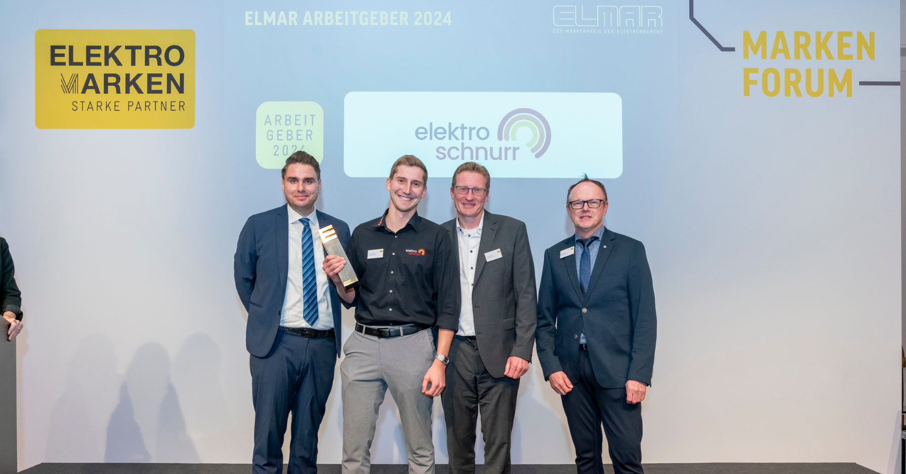 Hansjörg und Christoph Schnurr von Elektro Schnurr sowie ein Vertreter des Arbeitskreises Elektromarken Starke Partner bei der Verleihung des ELMAR 2024. Elektro Schnurr wird für seine starke Arbeitgebermarke ausgezeichnet.