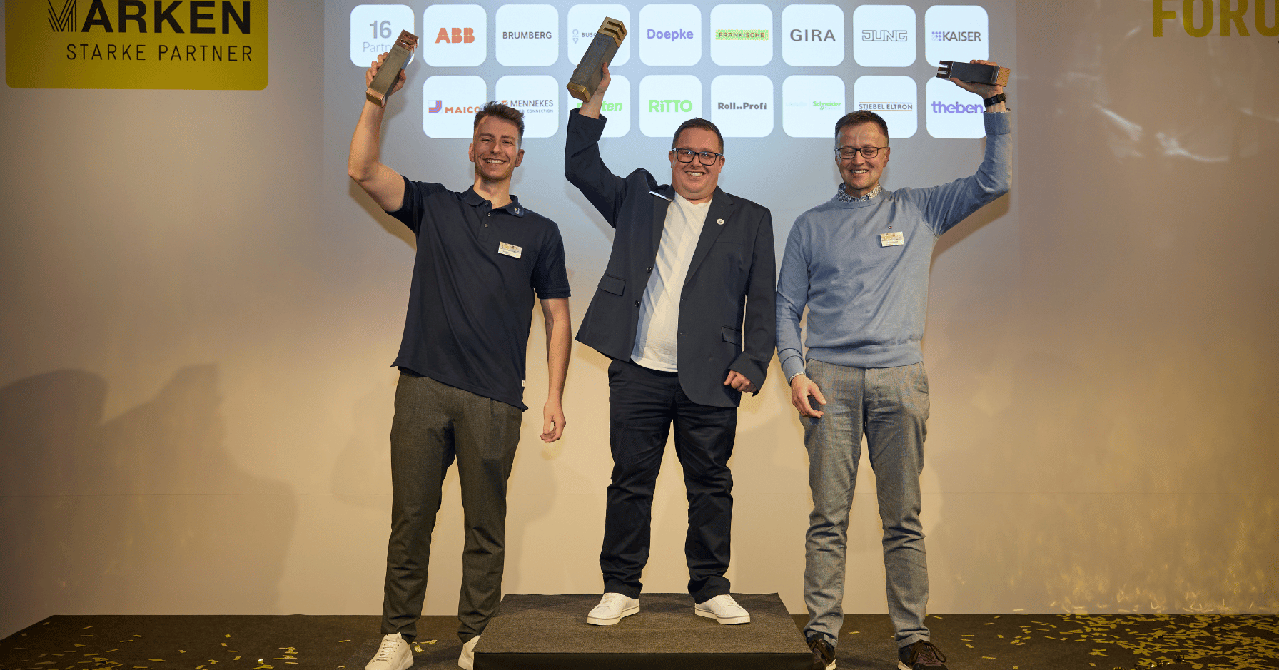 Die Gewinner des ELMAR 2025 in der Kategorie 2 (11–30 Mitarbeitende) feiern gemeinsam auf der Bühne des Markenforums. Baumeister Elektrotechnik aus Iserlohn (Gold), iQma energy GmbH & Co. KG aus Eslohe (Silber) und TK-Energietechnik GmbH aus Albershausen (Bronze) präsentieren ihre ELMAR-Auszeichnungen.